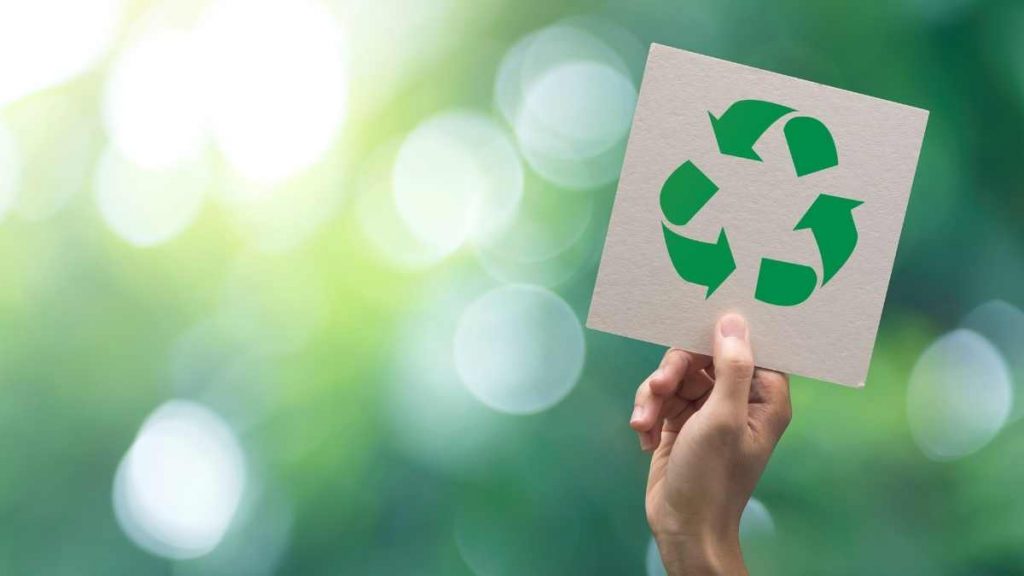 recycle sign on card being held in the air