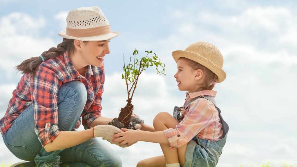 mom and daughter planting a tree