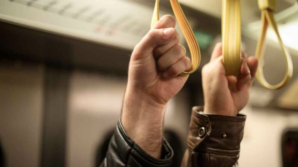 public transport people holding on underground train